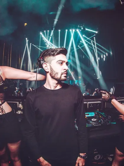 A shot from the booth, flanked by professional dancers under dramatic stage lighting. This reflects the high-production value and immersive experience of the events I headline.
