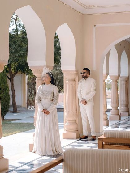 An architectural portrait of the couple in a palace corridor, using the columns to create depth and drama.