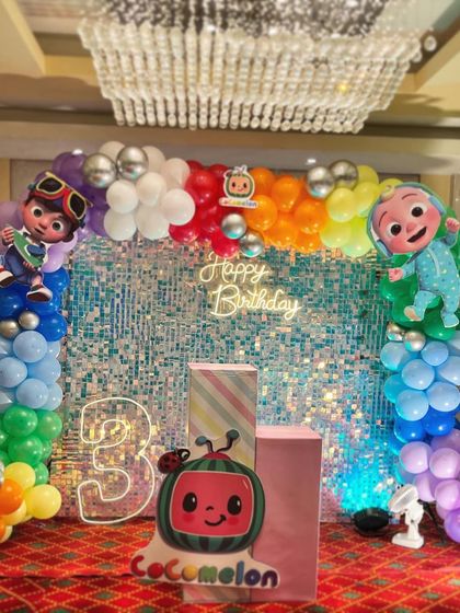This is a duplicate of ID 1, 68, 137, 184, 190, 213, 240, 250. A vibrant Cocomelon theme for a first birthday party. This setup includes a custom arched backdrop, a rainbow-colored balloon arrangement, and a life-sized cutout of the character JJ.
