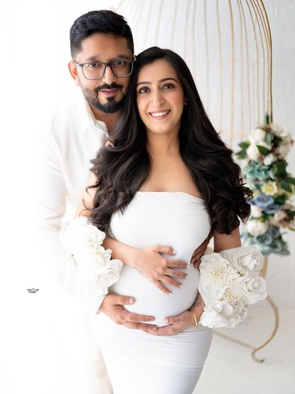 A beautiful portrait of the couple, both looking at the camera, radiating happiness. The birdcage prop adds a touch of whimsy.