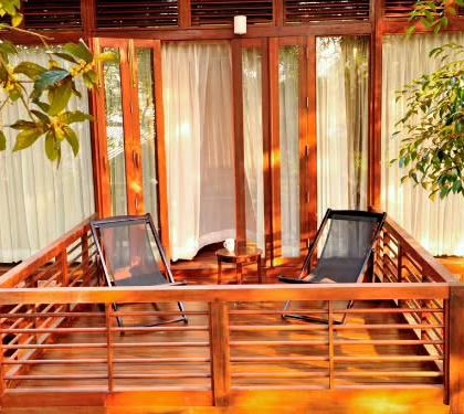 The private wooden balcony of a nature lodge in Coorg. This is the perfect spot to enjoy your morning coffee while listening to the sounds of the forest and watching the mist roll over the hills.