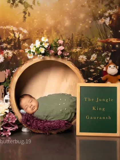 We can personalize any setup with a custom sign. Here, a chalkboard announces "The Jungle King," adding a fun touch to this jungle-themed newborn shoot.