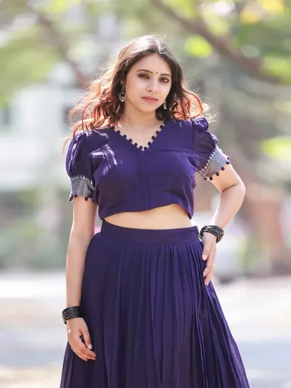 A full-length shot of the admiral blue half-saree. The puff-sleeved blouse with a tie-up back adds a modern twist to the traditional silhouette.