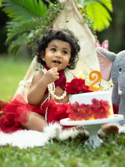 A little taste of the birthday cake. The natural light and green background of the park setting make the colors of this second birthday shoot pop.