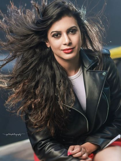 A high-energy, modern fashion shoot featuring a model with a luxury sports car. The edgy styling with a leather jacket and bold red pants creates a powerful, confident look.