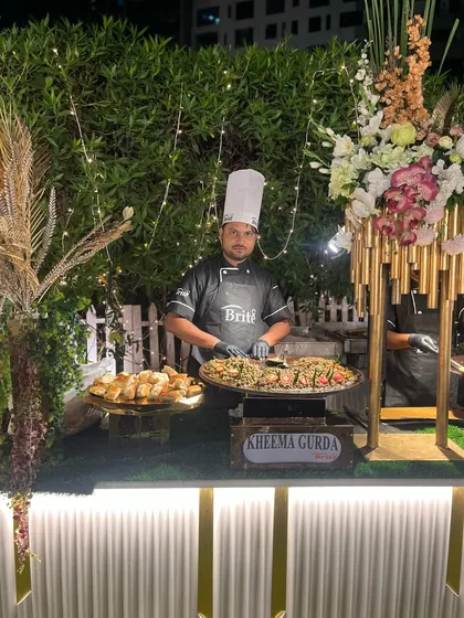 A portrait of my chef at the beautifully lit Kheema Gurda station, highlighting the professional and stylish presentation of my live counters.