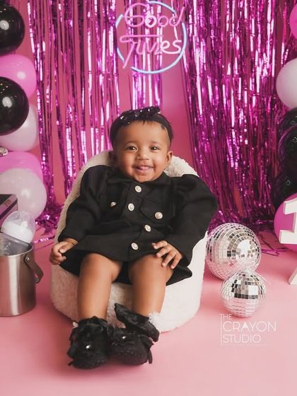 The other twin enjoying her moment in the spotlight, with a big smile for the camera during their half-birthday session.