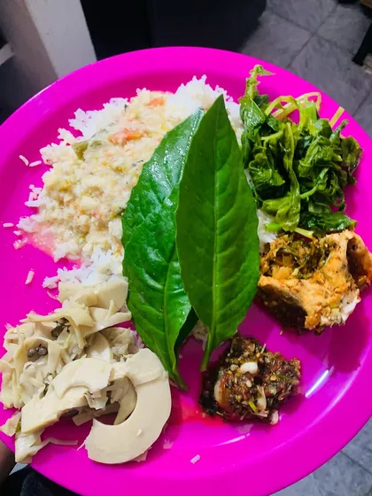 A simple and beautiful river fish lunch thali. On the plate, you have rice, boiled bamboo shoot, a simple vegetable stir fry, and a spicy chutney, all served with fresh leaves.