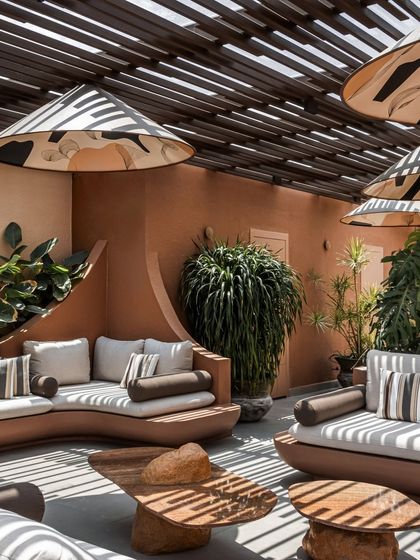 The curved forms of the built-in sofas soften the architecture and create a natural, flowing layout. This design choice enhances the feeling of a relaxed, welcoming outdoor living room.