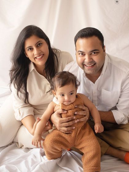 A sweet and simple family portrait. The neutral-colored outfits and clean white background keep the focus right where it should be: on the family's happy faces.