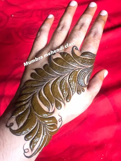 A single, bold leaf motif on the hand. This is a great example of how a simple design can have a huge impact.