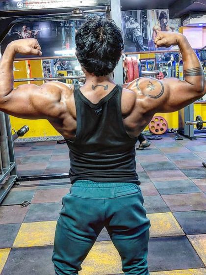 Showing a powerful back double bicep pose. Building a strong back is crucial for overall physique and strength, a key focus in my training programs.