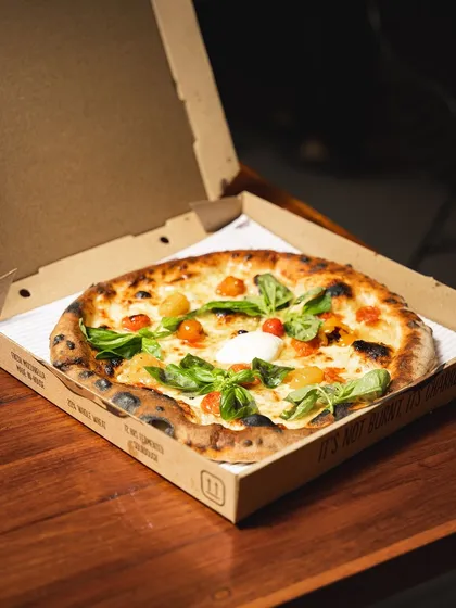 A travel-friendly pizza in one of our custom boxes. We've refined our process to ensure our Neapolitan pizzas hold up during delivery without sacrificing quality.