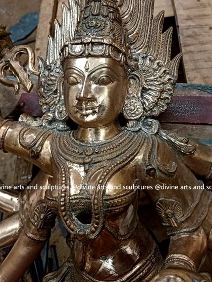 A close-up of a Bhadrakali idol during the finishing process. The raw bronze has been cast and is now being chiseled and defined to bring out the sharp, divine features.
