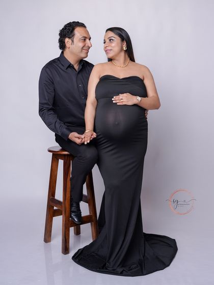 A stylish couple's portrait featuring a classic black gown. The interaction between the two creates a feeling of shared happiness and connection.
