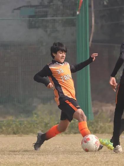 A player dribbles past opponents during a U15 Gurgaon Winter Cup match.