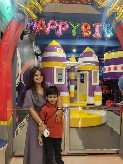 A mother and son pose in front of our rocket ship play structure. It's a perfect spot for a memorable photo.