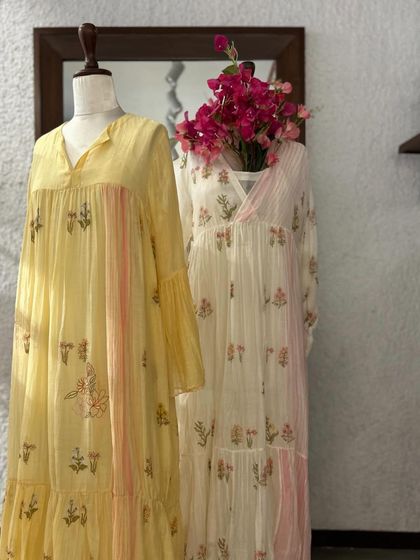 Two easy-breezy summer dresses with floral block prints, one in soft yellow and the other in ivory, perfect for a relaxed day out.