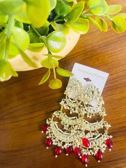 For a classic wedding look, these tiered chandbalis with bright red beads are a perfect match. They pair beautifully with traditional red and gold outfits.