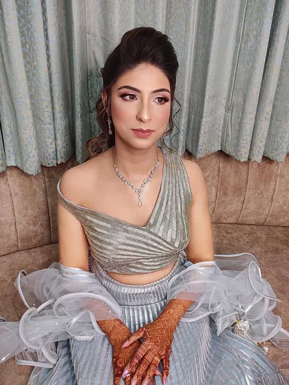 This client was like a doll, and I created a subtle glam look to match. The off-shoulder top and ruffled dupatta add a modern touch to her engagement style.