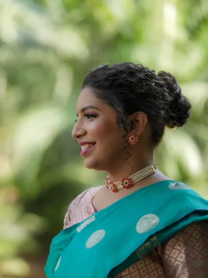 A side profile view of the bride, highlighting her elegant hairstyle and the pretty details of her choker.