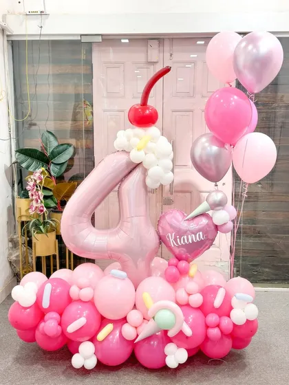 Sweet and delightful, this ice cream-themed arrangement was for a 4th birthday. The number '4' is topped with a balloon cherry, and the base is decorated with sprinkles and tiny ice cream cones for a fun, whimsical touch.