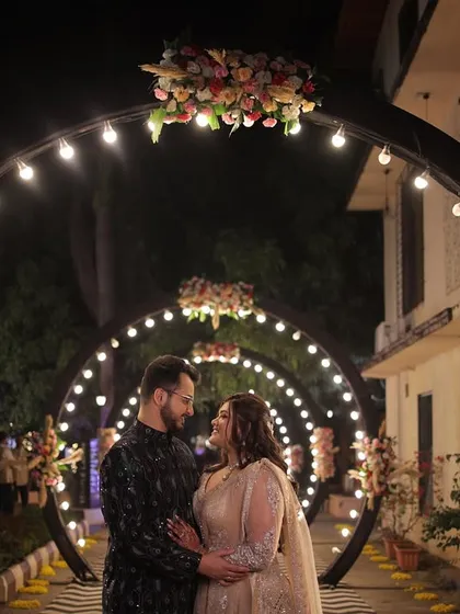 A couple shares a romantic moment under a tunnel of lights at their Sangeet. I design these immersive entryways to make the couple's entrance a magical and memorable part of the evening.
