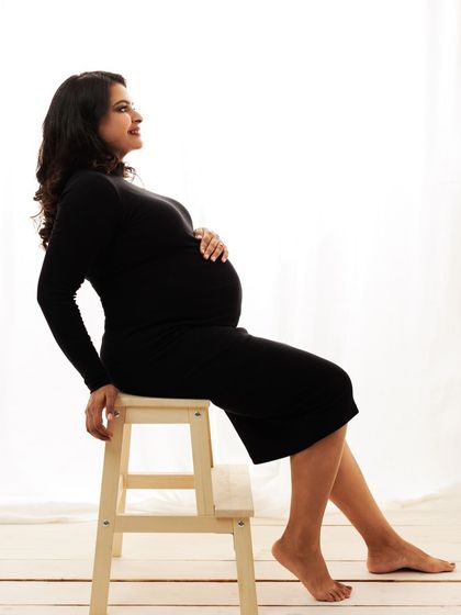 A simple, elegant pose of the mother-to-be, her profile beautifully lit against the white background.