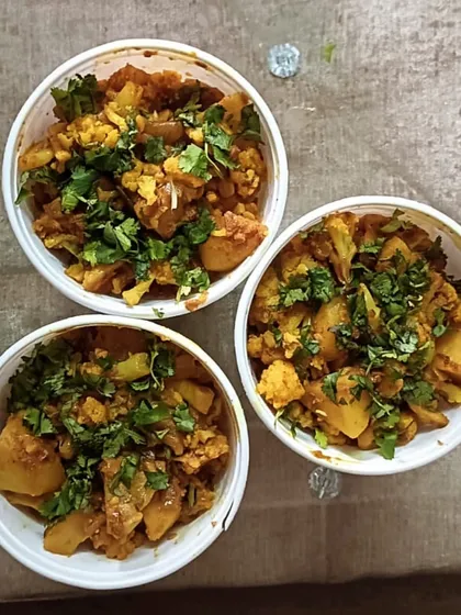 Bowls of freshly made Aloo Gobi, ready to be packed for an order. I always use fresh vegetables and garnish with coriander.