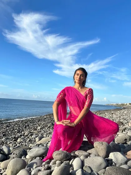 A seated dance pose on a beach, conveying a moment of calm and contemplation. This type of pose is ideal for wellness or lifestyle brands that want to evoke a sense of peace.