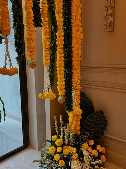 Another angle of the traditional marigold decor, showing how the floral arrangements frame the entrance and create a warm, festive atmosphere.