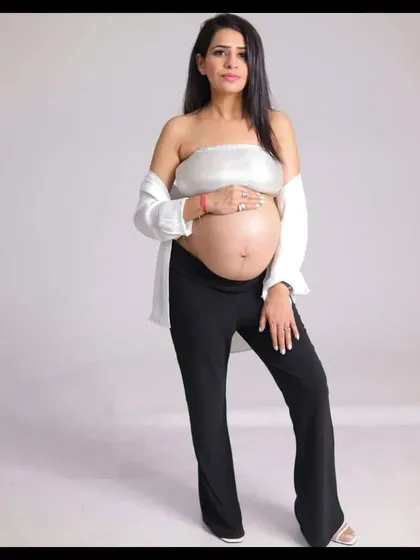 A confident and modern bare-bump portrait. This shot celebrates the beauty of the pregnant form with simple, clean styling and a focus on the mom-to-be's radiant glow.