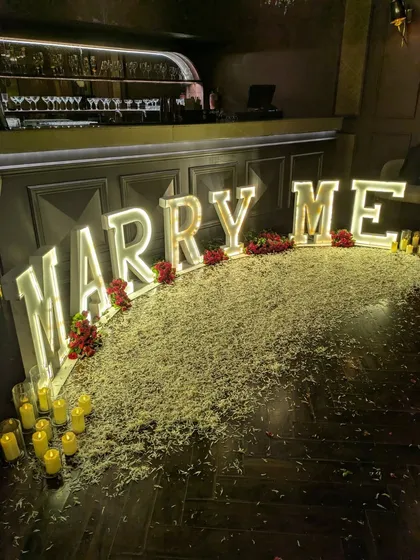 A detailed close-up of the illuminated letters and the texture of the faux grass and rose petals. Every element is chosen to contribute to the overall look and feel.