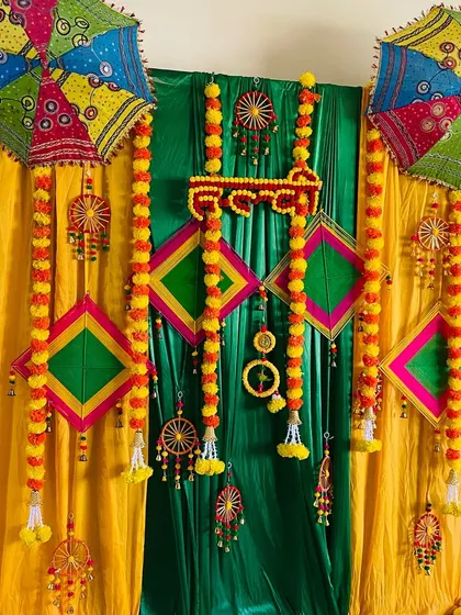 Another angle of the colorful Haldi backdrop with traditional umbrellas and kites.