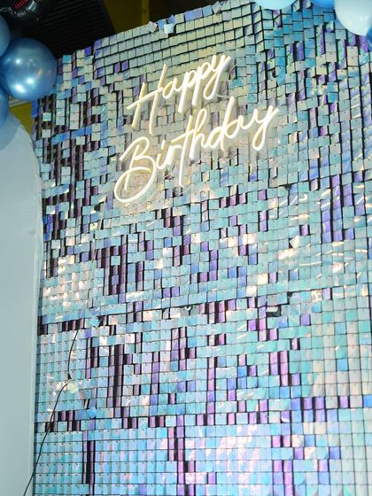 The iridescent shimmer wall was a fantastic backdrop for the cake cutting. The "Happy Birthday" neon sign adds a modern and celebratory touch to the car-themed decor.