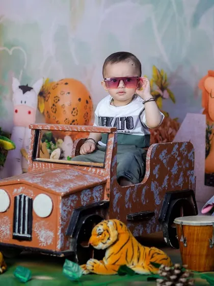 A cool little dude in sunglasses, ready for his jungle adventure. The variety of stuffed animals creates a rich and playful scene.