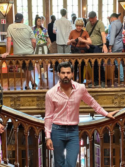 Inside a historic, ornate building, the modern style of the candy stripe shirt creates a beautiful contrast, showcasing its versatility.