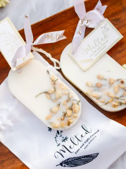 A flatlay of jasmine-infused wax sachets on a wooden tray with their elegant packaging. The composition is clean and simple, highlighting the handcrafted quality and delicate aroma of the product.
