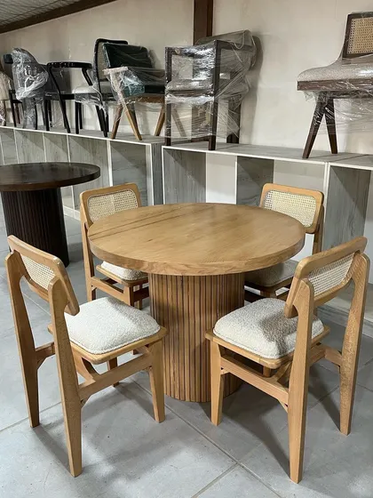 A four-seater dining set in my workshop. The round table has a fluted base, and the chairs have caned backrests and comfortable upholstered seats.