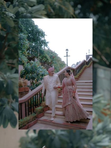 An artistic shot of the couple on the staircase, framed by foliage, creating a natural and romantic feel.