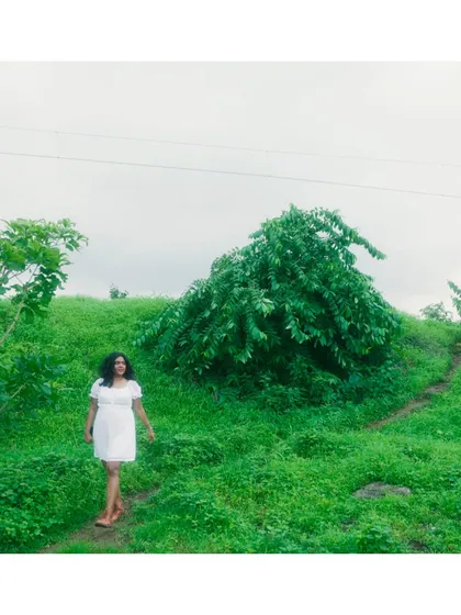 Walking through a lush green landscape in a still from the "Barsa Hai" music video.