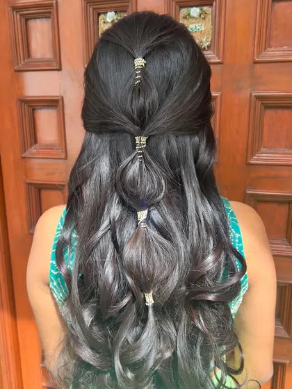 A unique and modern half-updo featuring bubble braids secured with golden cuffs.