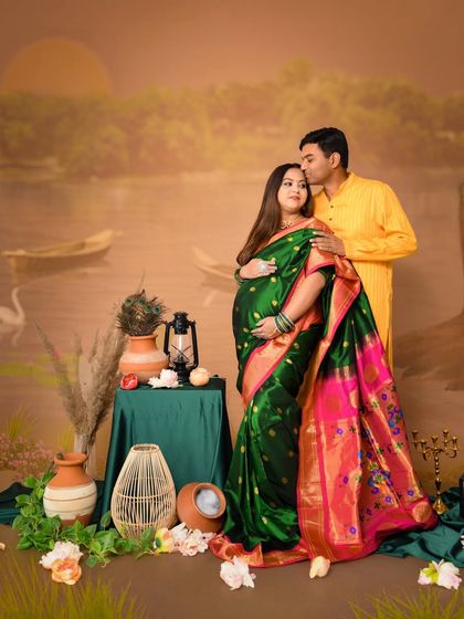 A tender moment between the couple during their traditional maternity shoot. The partner's gentle kiss on the forehead adds a layer of warmth and affection to this culturally rich portrait.