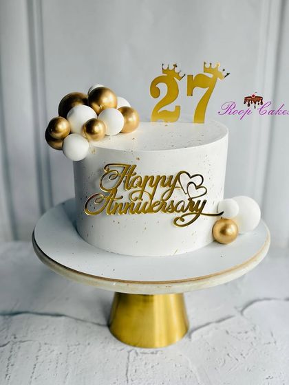 Celebrating 27 years of love and togetherness with this chic and elegant anniversary cake in white and gold.