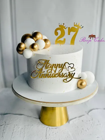 Celebrating 27 years of love and togetherness with this chic and elegant anniversary cake in white and gold.