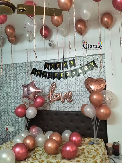 A classic anniversary room decoration. We fill the ceiling with balloons, scatter them on the bed, and add a 'Happy Anniversary' banner and 'love' foil balloon for a sweet surprise.