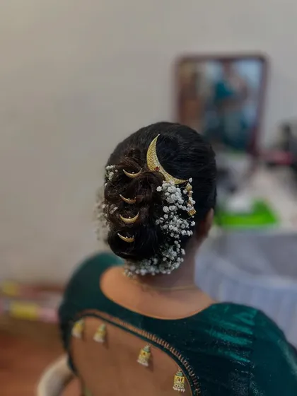 A detailed look at the traditional 'khopa' hairstyle, decorated with baby's breath and moon-shaped hairpins.