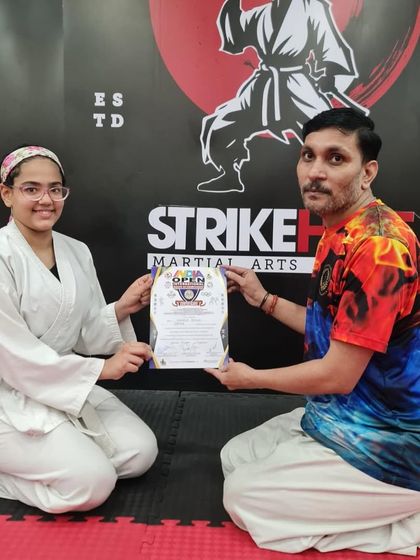 A student receives her certificate at the India Open Karate Championship, showcasing her hard work and the quality of our training.