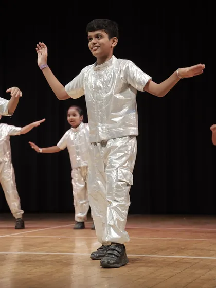 A student from the 'Swagger Boys' group with open arms, fully embracing the stage. Our program is designed to make every dancer feel like a star.