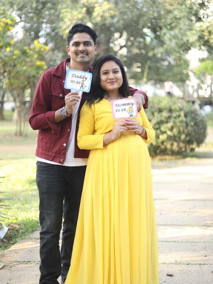 A cute "Mommy to be" and "Daddy to be" photo. Her makeup is bright and cheerful, matching the happy announcement.